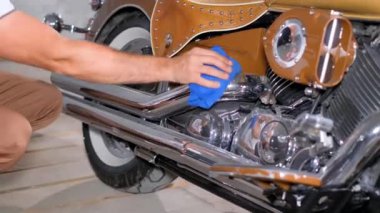 Bir motorcu motosikletini temizler ve yıkar. Motosikletlerin bakımı ve bakımı.