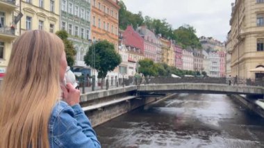 Çek Cumhuriyeti 'nin Karlovy Vary şehrinde duran bir kadın su içiyor.