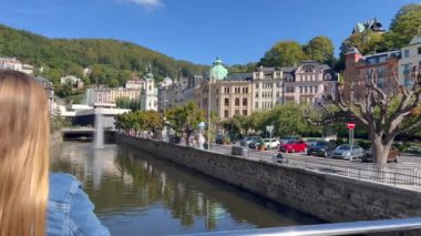 Sarışın kadın doğayla iç içe güzel şehir manzarasına bakıyor Karlovy Vary, Çek Cumhuriyeti.
