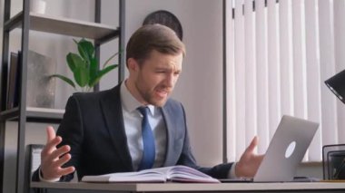 Duygusal olarak sinirli ofis çalışanı, menajer, sinirli, video aracılığıyla iş arkadaşıyla konuşan, hoşnutsuz yüz ifadesi, el hareketleri.
