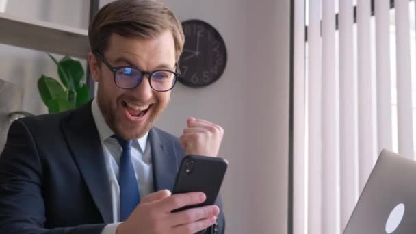 Удивлённый Счастливый Бизнесмен Держит Телефон Смотрит Мобильный Телефон Читает Хорошие — стоковое видео
