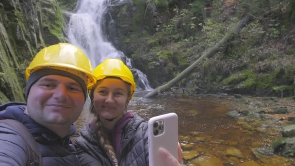 Szczęśliwa Para Podróżuje Robią Zdjęcia Przy Górskim Wodospadzie Koncepcja Podróży — Wideo stockowe