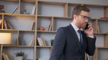 Gözlüklü kızgın iş adamı telefonda konuşuyor. Ofis müdürü işte..