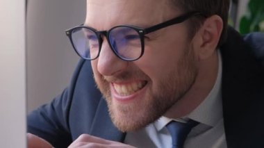 Bilgisayar ekranına bakan yabancı bir ofis çalışanının yakın çekimi. Komik iş adamı..