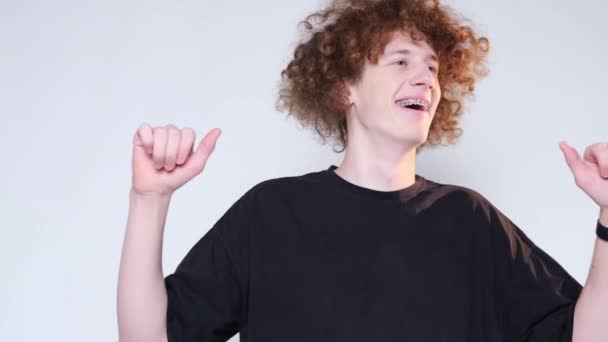 Gülümseyen Kıvırcık Genç Adam Beyaz Bir Arka Planda Dans Ediyor — Stok video
