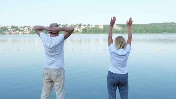 Una Pareja Madura Haciendo Yoga Levantando Las Manos Conexión Armonía — Vídeos de Stock