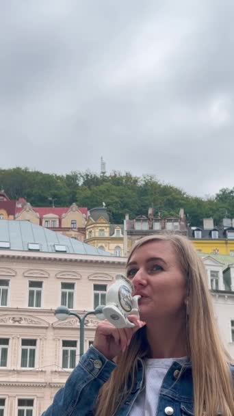捷克共和国卡洛维瓦里 一名旅游妇女从药用温泉喝水 治疗和康复或复原的概念 垂直录像 — 图库视频影像