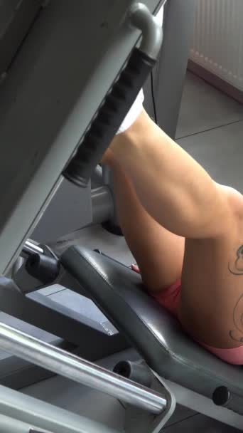 Uma Mulher Realiza Exercícios Perna Com Pesos Uma Máquina Exercícios — Vídeo de Stock
