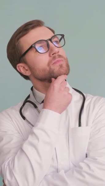 診療所の白い医療服に眼鏡をかけている医師の垂直ビデオ バーティカルビデオ — ストック動画