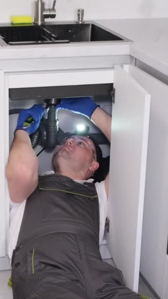 Sanitair Onder Gootsteen Keuken Een Loodgieter Een Grijs Uniform Repareert — Stockvideo