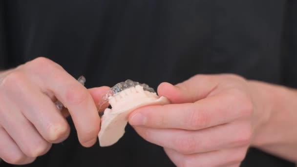 一个牙齿矫正专家一边说牙齿矫正 一边拿着一个人类下巴模型 牙齿对齐的概念 牙科学 — 图库视频影像