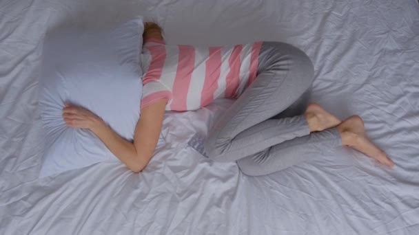 女性の毎月のサイクル 彼女はベッドの上に横たわり 絶望と不安 孤独を感じる — ストック動画