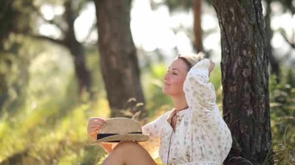 아름다운 여자가 숲에서 잔디에 앉아있다 여자는 자연에서 날씨를 즐긴다 긍정적인 — 비디오