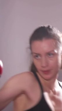 Bir kadın boks yapar. Dikey video.