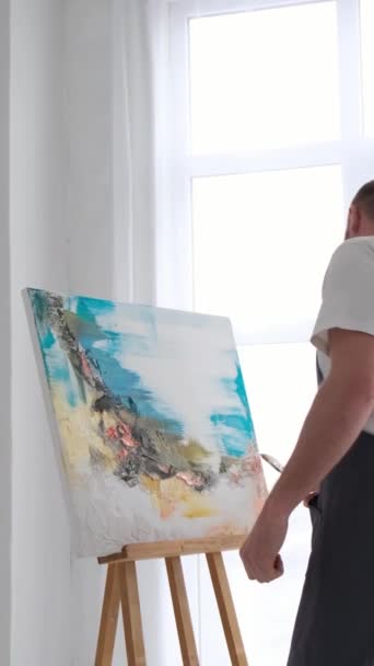 Male Artist Paints Picture Studio Vertical Video — Stock Video