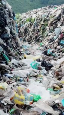 Bir sürü çöplükle dolu bir çöplük. Dikey video. Kirlenmiş topraklarda ekolojik hasar. Kirlilik kavramı.