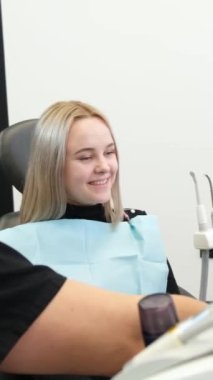 Dişçi randevusundaki genç bir kadın. Dikey video.
