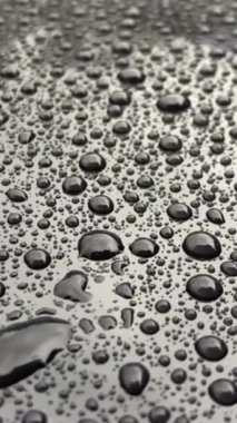 Bardağın üzerine büyük yağmur damlaları. Dikey video.