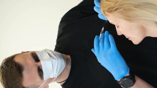 医者は老婆の顔に注射する 老化するプロセス バーティカルビデオ — ストック動画