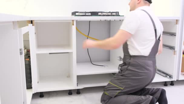 Een Man Verzamelt Keukenmeubels Reparatie Van Keuken Met Behulp Van — Stockvideo
