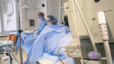 Damarları çıkarmak için yapılan ameliyat sırasında bir cerrah ekibi - flebektomi. Klinikte cerrahi operasyon.