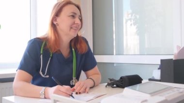 Ofisteki bir hastaya ilaç yazan bir kadın doktorun portresi. ABD 'de sağlık sigortası..