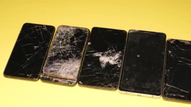 Tamir servisindeki bozuk akıllı telefonlar. Kırık akıllı telefon ekranı.