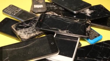 Bir tamirhanede bir sürü bozuk akıllı telefon var. Kırık akıllı telefon ekranı.
