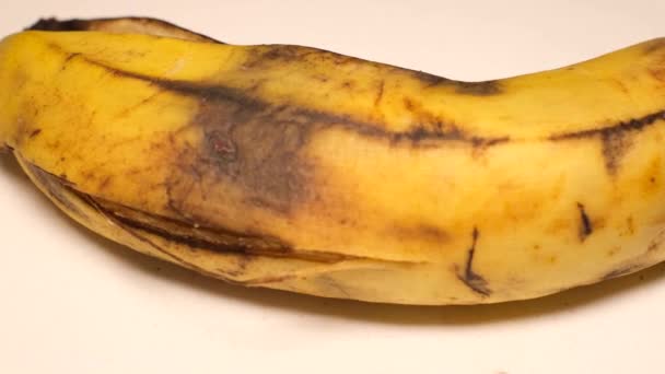 腐烂的香蕉在白色的背景上旋转 变质的水果 — 图库视频影像