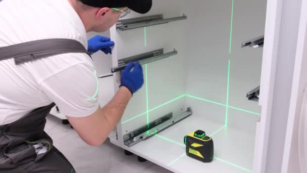 Mężczyzna Kolekcjonuje Meble Kuchenne Naprawa Kuchni Używanie Lasera Budowlanego — Wideo stockowe