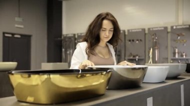 Bir kadın lavabo ve musluk alır. Tesisat dükkanı..