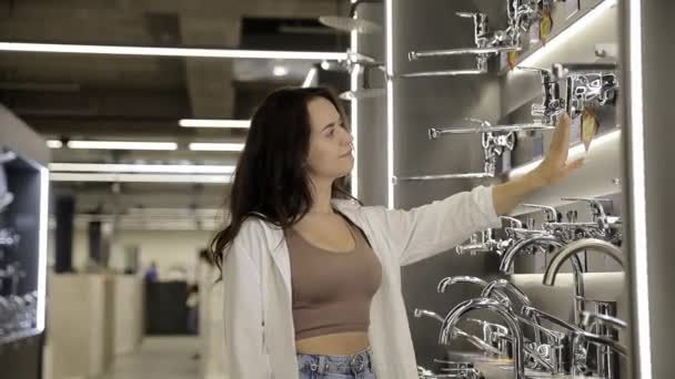 Eine Schöne Frau Wählt Einen Wasserhahn Einem Geschäft Für Küchenzubehör — Stockvideo