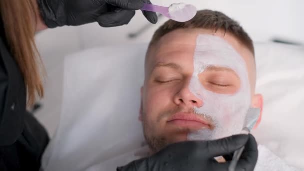 미용사는 화장품 클리닉에서 장갑을 사용하여 얼굴에 마스크를 — 비디오