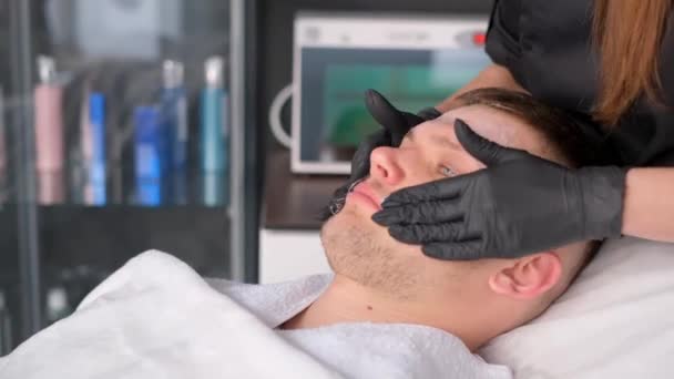 Profesyonel Bir Kozmetikçi Genç Bir Adamın Yüzüne Elleriyle Masaj Yapar — Stok video