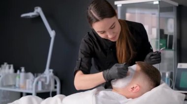 Güzellik salonunda yüz maskesi takan yakışıklı bir adam. Genç bir adam estetik yüz soyma ameliyatı oluyor. Kozmetoloji ve Gençleştirme.
