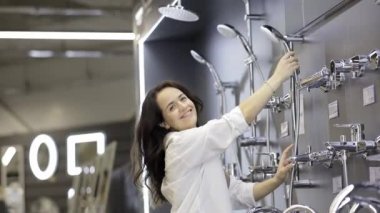 Bir müşteri, bir tesisat dükkanındaki duş başlığına bakıyor. Ev tasarımı kavramı.