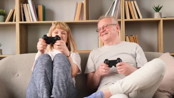 Ηλικιωμένο Ζευγάρι Παίζει Βιντεοπαιχνίδια Απευθείας Σύνδεση Κρατώντας Ελεγκτές Παιχνιδιών Διασκεδάζοντας — Αρχείο Βίντεο