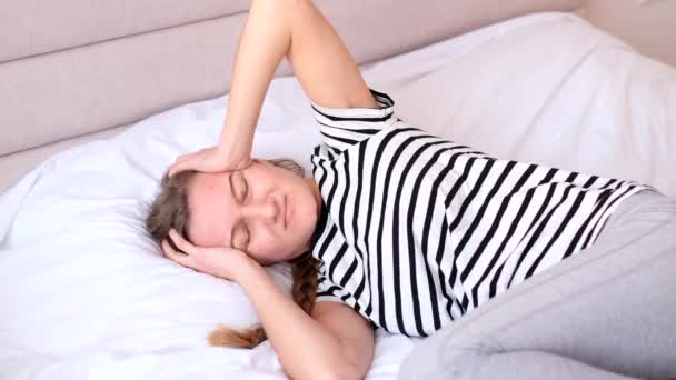 痛苦不堪地抱头躺在床上 突然发作偏头痛 得了感冒 非常不快乐的女人 — 图库视频影像