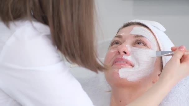Cosmetologo Applica Una Maschera Alla Panna Con Vitamine Viso Femminile — Video Stock