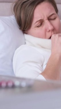 Bir kadın nezle olmuş, grip. Boğaz ağrısı, öksürük ve ateş. Soğuk algınlığı, öksürük. Dikey video