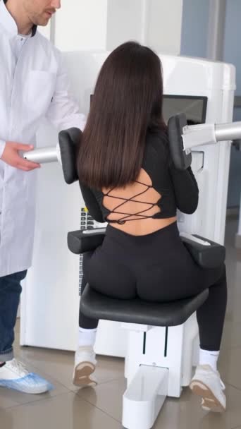 Vertical Video Professional Vertebrologist Trains Woman Back Exercise Machine Treatment — Stock Video