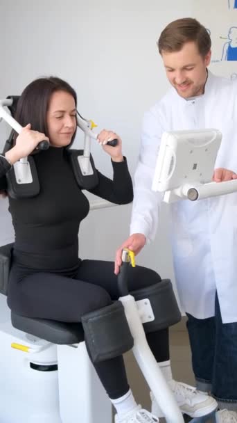 一个理疗病人与一名专业教练一起做运动的垂直录像 预防和治疗背部疾病 垂直录像 — 图库视频影像