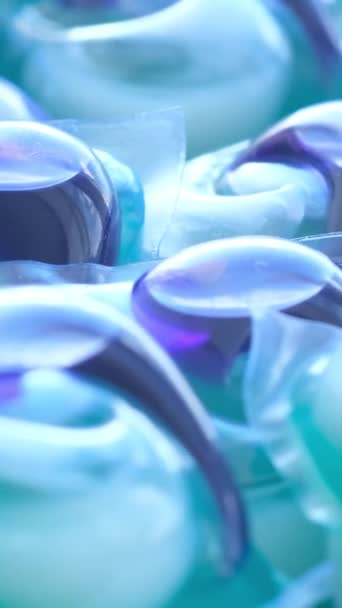自動マシンで服を洗うための青いカプセル 服を洗うという概念 バーティカルビデオ — ストック動画