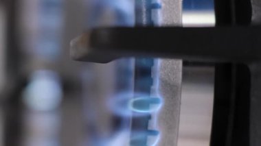 Mutfak ocağında ateş yakmak. Ocağın kızgın ateşine yakın çekim. Gaz mavi alevini yak. Ocakta bir alev yanıyor. Dikey video