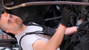 Arabanın yağını değiştiriyorum. Araba servisinde çalışırken araba tamircisi. Dikey video.