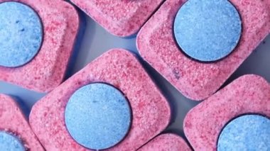 Bulaşık yıkamak için renkli kapsüller. Birkaç bulaşık kapsülü yığını dönüyor. Yukarıdan bak. Dikey video