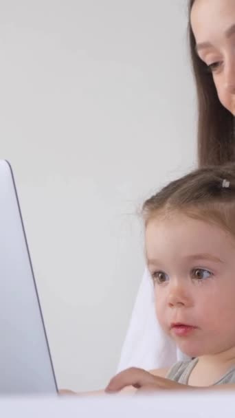 コンピューターで自宅で働く女性 小さな子供と働く母親 バーティカルビデオ — ストック動画