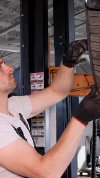Joven Mecánico Ajusta Neumático Solo Garaje Reparación Hombre Uniforme Trabaja — Vídeos de Stock