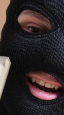 Erkek bir soyguncu kasadan para alıyor. Soygun tehlikesi. Hücum. Dikey video.