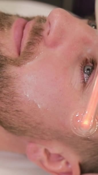 Young Man Undergoes Facial Rejuvenation Procedure Using Darsonval Salon Top — Stock Video